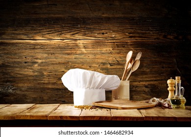 White cook hat with kitchen tools on wooden background - Powered by Shutterstock