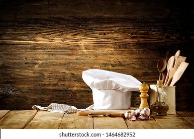 White cook hat with kitchen tools on wooden background - Powered by Shutterstock