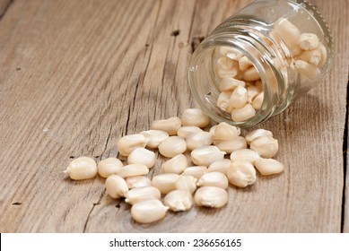 White corn and glass jar on old wooden table
