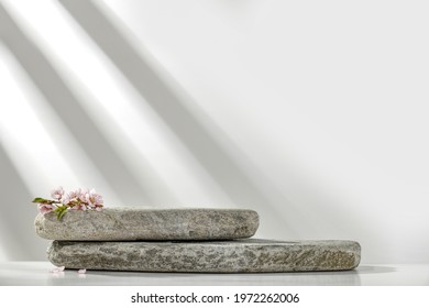 White cosmetic background of stones and wall with shadows. Free space for your decoration 