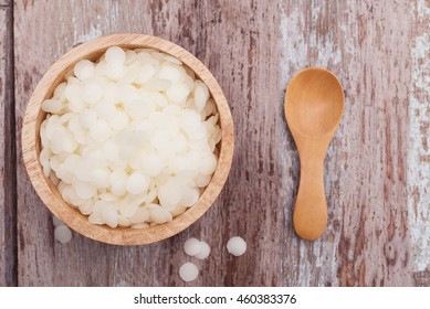 White Cosmetic Beeswax Pellets In Wooden Bowl On Wooden Background.
