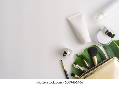White cosmetic products and green leaves on white background. Natural beauty products for branding mock-up concept.