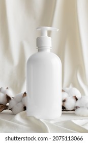 White Cosmetic Shampoo Dispenser Bottle Mockup With A Cotton Branch On The Yellow Textile.