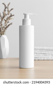 White Cosmetic Shampoo Dispenser Bottle Mockup With A Lavender And Towels On The Wooden Table.