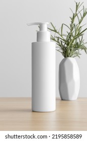 White Cosmetic Shampoo Dispenser Bottle Mockup With A Rosemary On The Wooden Table.