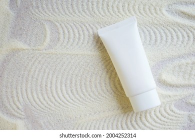 white cosmetic tube with face cream or body lotion on sandy background with pattern. Cosmetics concept with spf protection - Powered by Shutterstock