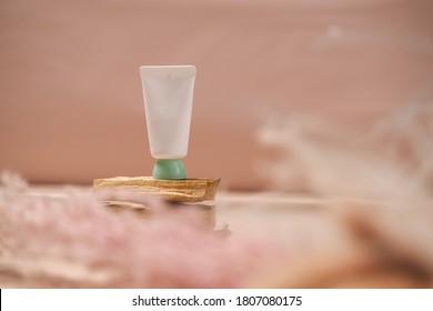 White cosmetic tube on light pink background. Natural minimalism, clean concept. Minimal styling, still life. Beauty blogging, skin care