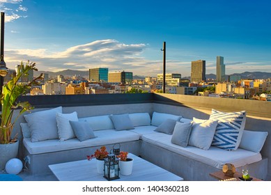 The white cosy sofa on an outdoor rooftop terrace with an amazing view on Barcelona downtown