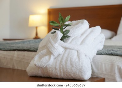 White cotton bathrobe with olive tree twig on the bed  in hotel room. Tourism, hotels, hospitality industry - Powered by Shutterstock