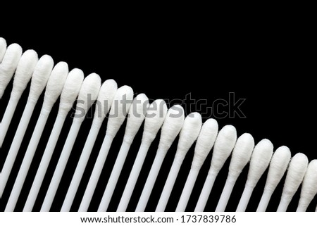White cotton buds are arranged in an orderly and beautiful way on a black background.