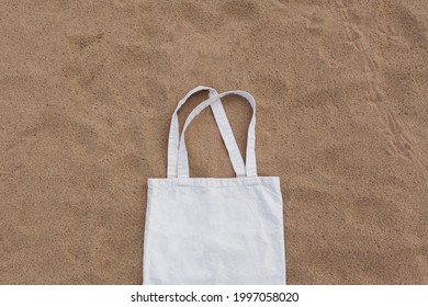 White cotton or mesh bag on beach sand background. Zero waste, no plastic, eco friendly shopping, recycling concept. Blank mockup shopper with place for artwork or text. Flat lay, copy space - Shutterstock ID 1997058020