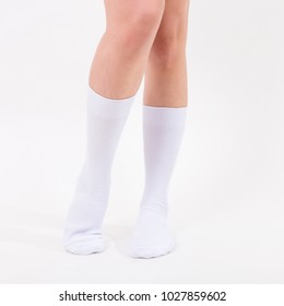 White Cotton Socks On Beautiful Woman's Feet. Isolated On White Background. Studio Lighting.