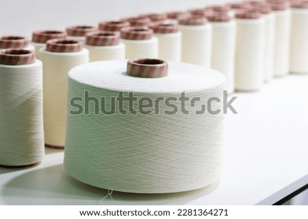 White cotton thread spools used in fabric and textile industry. Selective focus.