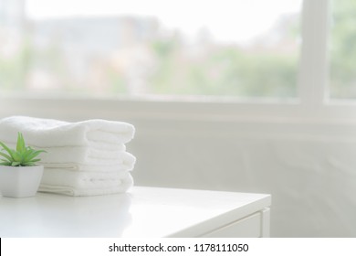 White Cotton Towels On White Counter Table Inside A Bright Bathroom Background. For Product Display Montage.