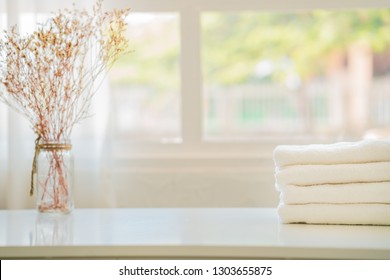 White Cotton Towels On White Counter Table Inside A Bright Bathroom Background. For Product Display Montage