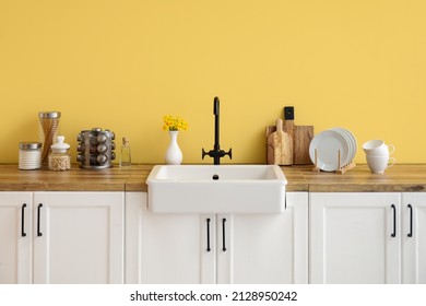 White Counters With Sink, Kitchen Utensils And Food Near Yellow Wall