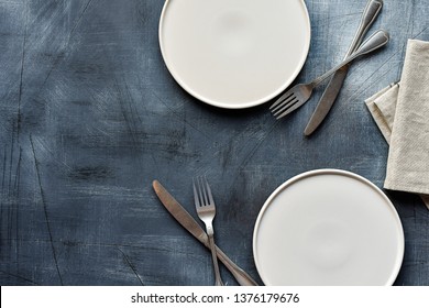 White craft plate, cutlery and napkin on dark stone table. Top view, copy space, Table setting. background for menu, layout, place for text , recipe background 