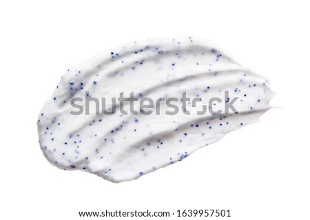 White cream cleanser scrub smear smudge isolated on white background. Skin care exfoliation cosmetic product creamy texture with blue particles