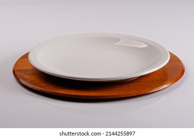 White Crockery Plate On Wooden Supla On White Infinite Background.