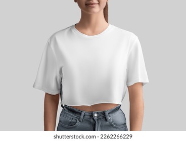White crop top mockup on a girl in jeans, isolated on background, front view. Free cut clothes template, oversized t-shirt for design, print, branding. Fashion casual shirt, women's clothing