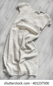 White Crumpled Lacy Dress On Wooden Floor As A Background