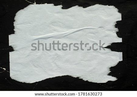 White crumpled paper pasted on a black wall.