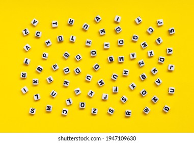 White cubes with letters scattered randomly on a yellow background. The Image can be used for many purposes, book covers or concepts relating to grammar and typography. - Shutterstock ID 1947109630