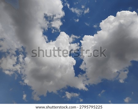 White cumulative  clouds float in the deep blue sky