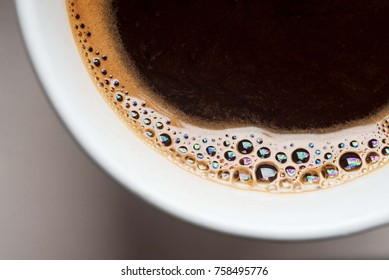 White Cup Of Black Coffee From Above. Top View Of Coffee Bubble Close Up. Caffeine Bubble Isolated.