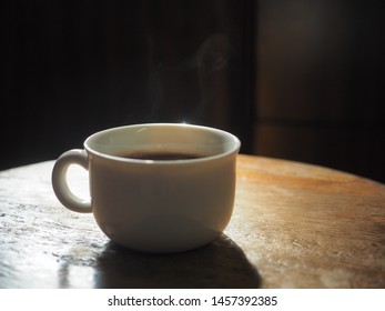 white cup of black coffee on wooden table - Powered by Shutterstock