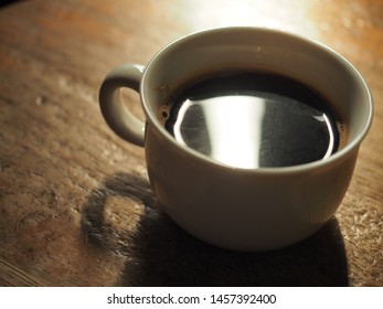 white cup of black coffee on wooden table - Powered by Shutterstock