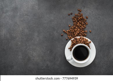 white cup with black coffee and roasted beans on stone background - Powered by Shutterstock