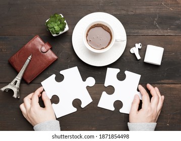 white cup with cocoa and two female hands holding white puzzle pieces on a brown wooden background, top view - Powered by Shutterstock