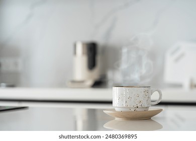 White cup of coffee on white kitchen table over blured kitchen interior background