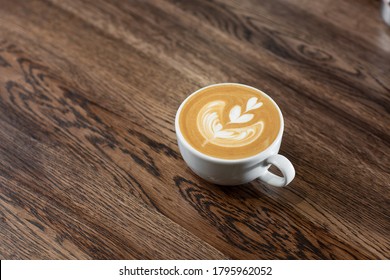 White Cup Of Hot Latte Coffee With Beautiful Milk Foam Latte Art Texture Isolated On Wooden Background. Overhead View, Copy Space. Advertising For Cafe Menu. Coffee Shop Menu.