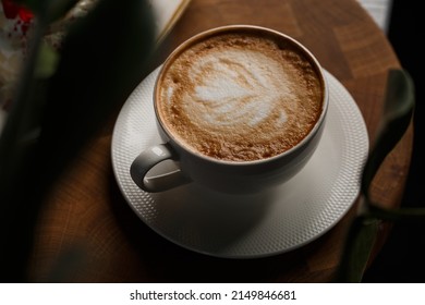 White Cup Of Hot Latte Coffee With Beautiful Milk Foam Latte Art Texture Isolated On Dark Background. Overhead View, Copy Space. Advertising For Cafe Menu. Coffee Shop Menu.