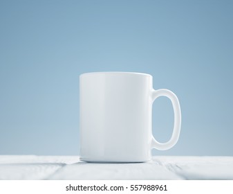 White cup mock-up inclined in center of wooden table