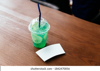 The White Cup Sleeve Of Green Iced Soda With Sliced Lemon On A Wooden Table. Cup Sleeve Template.