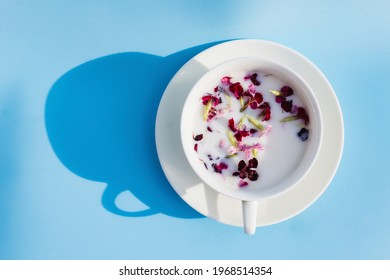 White Cup With Vegan Milk And Flowers On A Blue Background. Concept Of Vegetarian Drinks And Food, Herbal Teas, Beauty And Health, Spa.