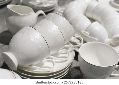white cups and saucers, empty ceramic dishes on the table, close-up.