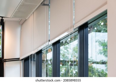 white curtain or white blinds Roller sun protection in office with garden view background.