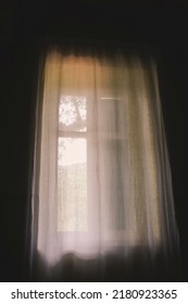 White Curtain In Dark Room. Morning Light Through Window.