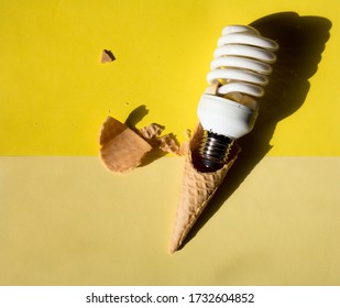 White Curved Lamp On A Bright Yellow Background With A Waffle Cone, The Bulb In The Horn Is Broken