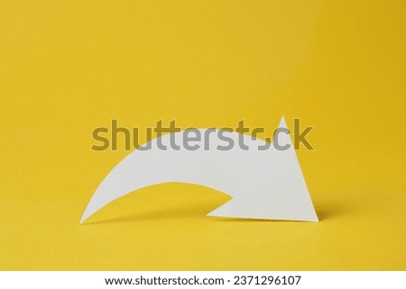 White curved paper arrow on yellow background