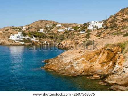 White cycladic architecture on the cliffs in Ios island, Greece. Blue sea and the blue sky at sunny day. Travel and summer vacation concept.