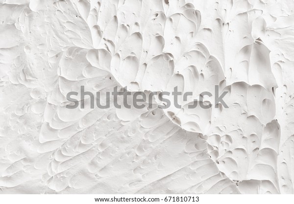 White decorative abstract plaster texture with\
craters and ripple.