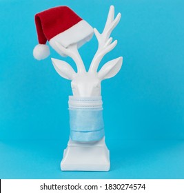 white deer in protective face mask on blue background, minimal creative concept of Christmas and New Year Stock Photo