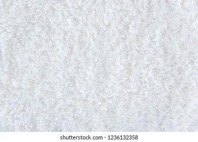 White delicate soft background of fur plush smooth fabric. Texture of beige soft fleecy blanket textile
