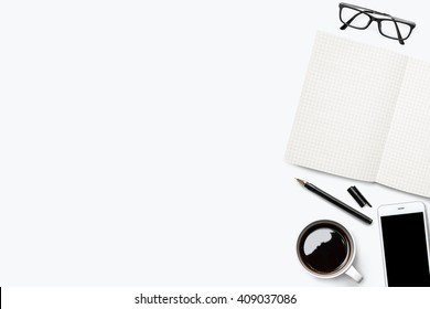 White Desk With Grid Lined Notebook And Other Supplies. Top View With Copy Space.