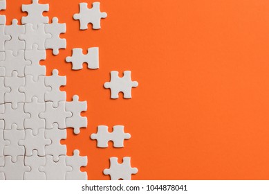 White details of puzzle on orange background.